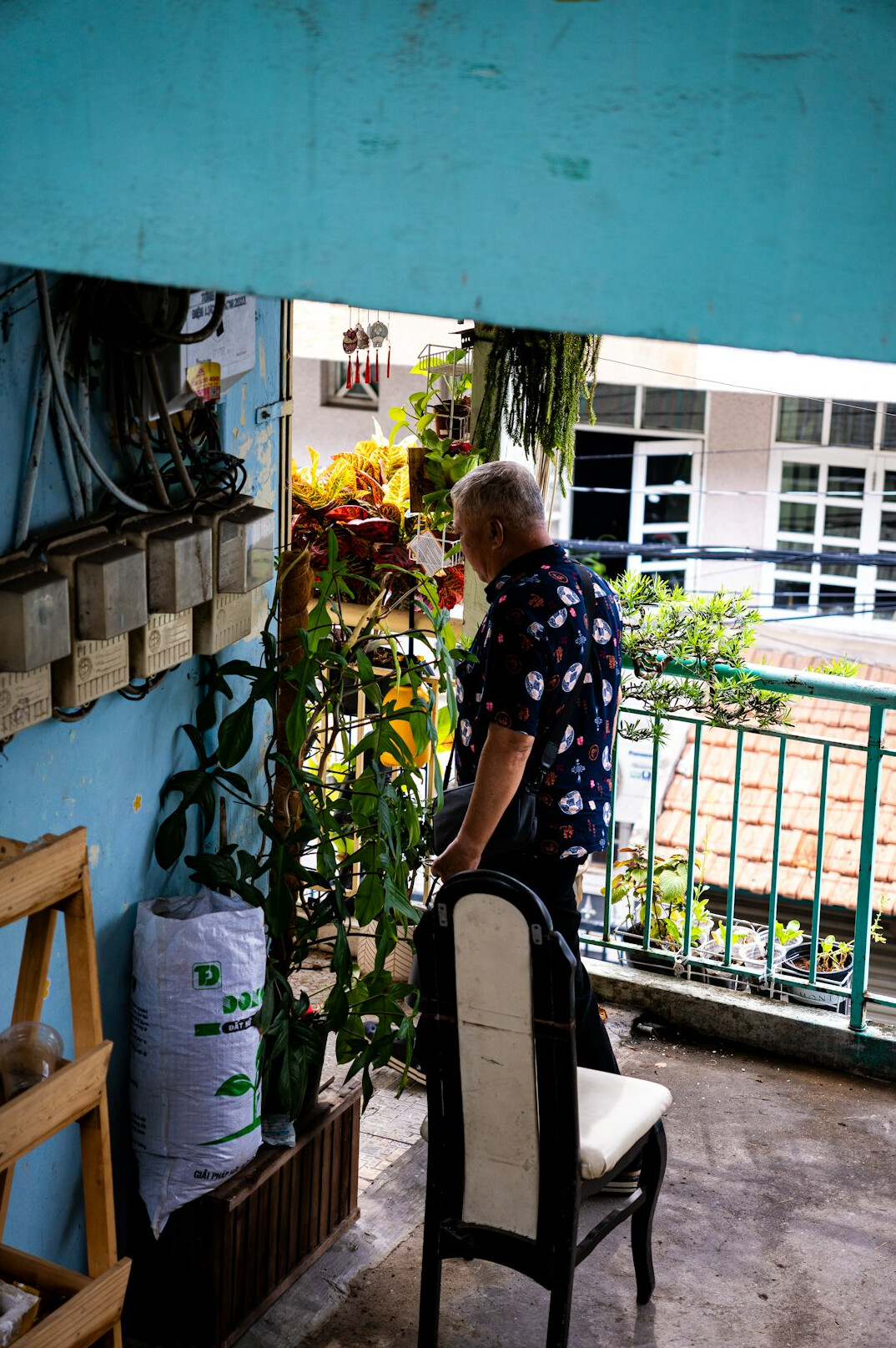 person watering balcony plants